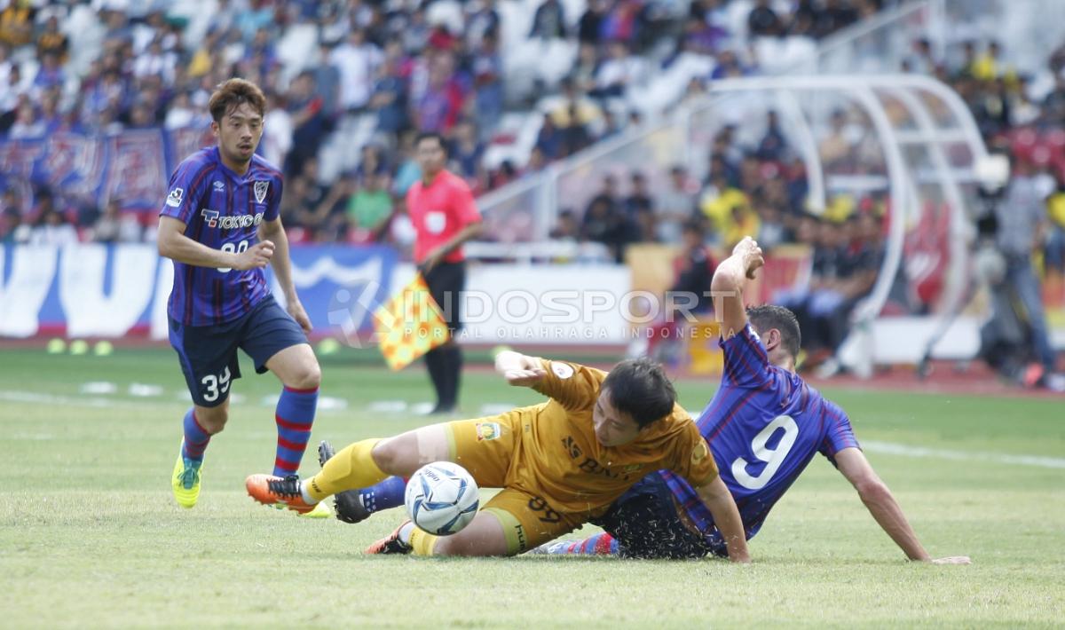 Pemain BFC, Lee Yoo Jun (tengah) berjibaku dengan pemain FC Tokyo. Copyright: Herry Ibrahim/Indosport.com