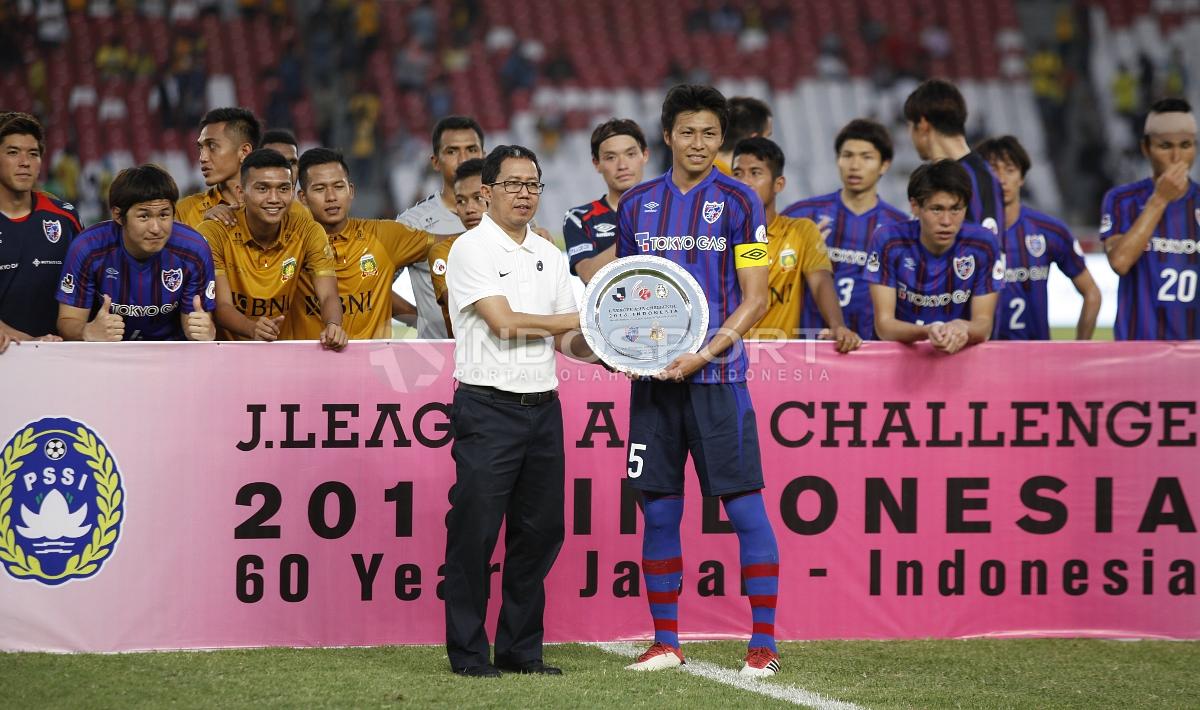 Wakil Ketum PSSI, Joko Driyono menyerahkan piala kemenangan atas uji coba dalam merayakan 60 tahun Hubungan Diplomatik Indonesia-Jepang kepada kapten FC Tokyo, Yuichi Maruyama.