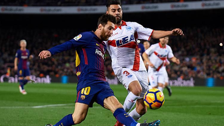 Lionel Messi dihadang oleh pemain Alaves. Copyright: INDOSPORT