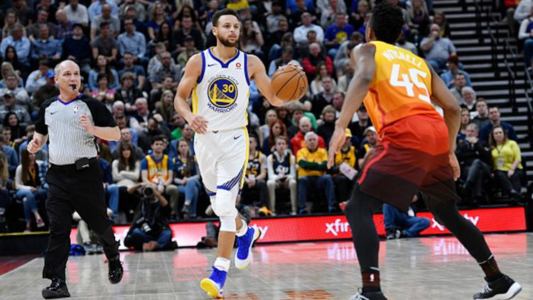 Stephen Curry tengan membawa bola akan melewati lawan. Copyright: INDOSPORT