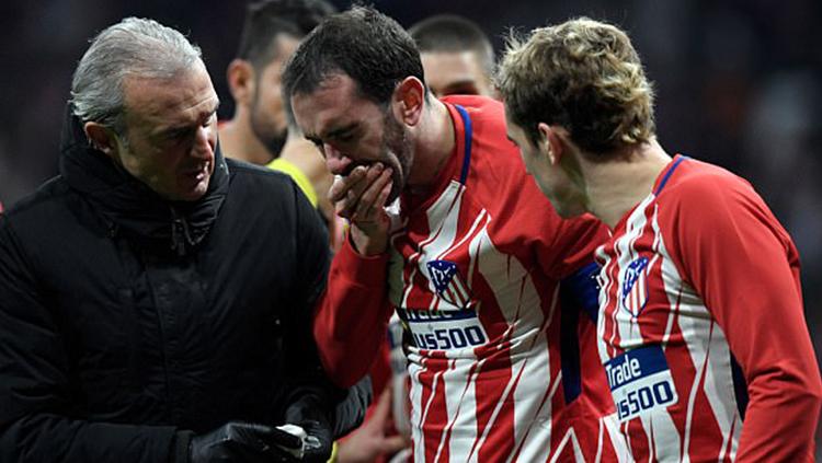 Gigi Diego Godin tampak berdarah setelah berbenturan dengan kiper Sevilla. Copyright: INDOSPORT