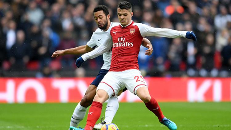 Mousa Dembele berusaha menggagalkan aksi Granit Xhaka. Copyright: INDOSPORT