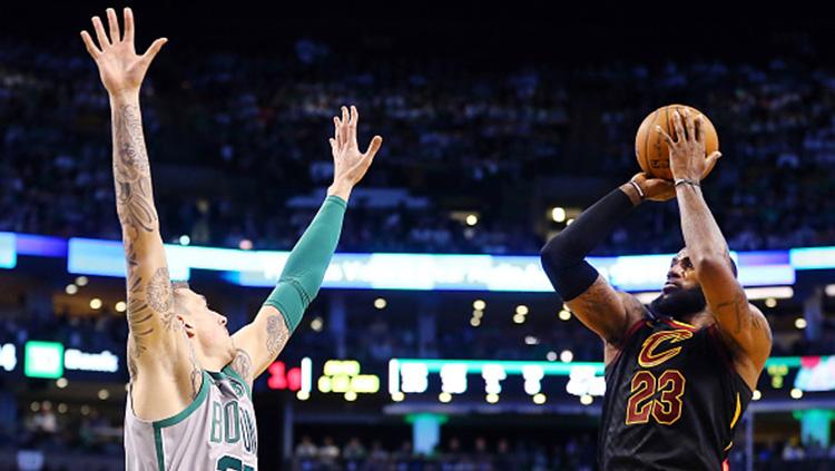 Lebron James shot bola dan Daniel Theis berusaha menjaganya. Copyright: INDOSPORT