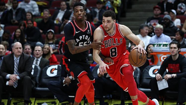 Zach LaVine (kanan) dari Chicago Bulls melewati pemain Toronto Raptors.