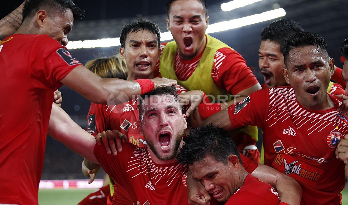 Marko Simic di tengah pemain Persija Jakarta lain yang tampak emosional merayakan gol.