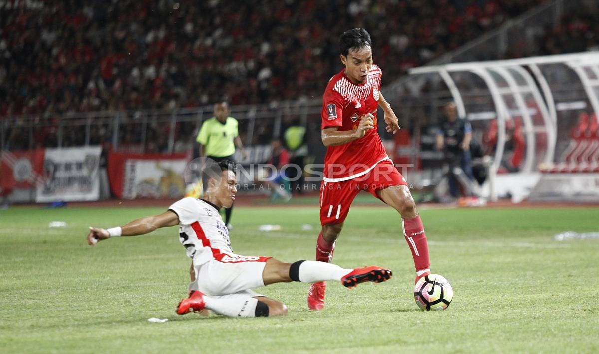 Pemain Persija Jakarta, Novri Setiawan tampak dicegah pergerakannya oleh pemain Bali United.