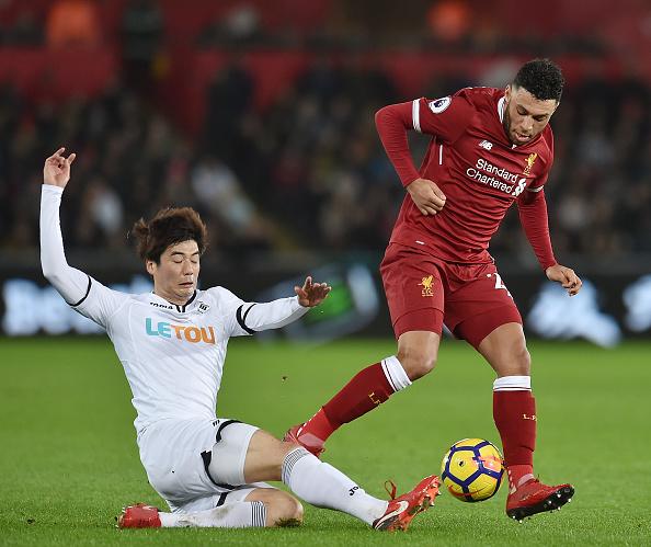 Sun-yeung Ki menekel pemain Liverpool, Chamberlain. Copyright: Getty Images