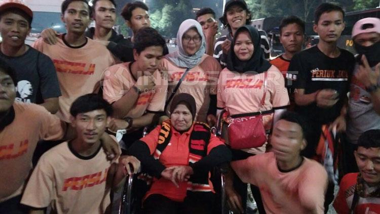 Nenek Rahma, The Jakmania Berkursi Roda foto bareng dengan Jakmania lainnya. Copyright: Abdul Aziz/INDOSPORT