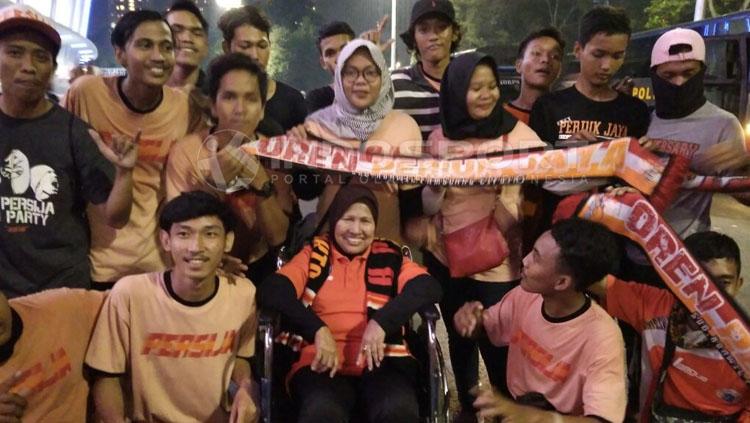 Nenek Rahma, The Jakmania Berkursi Roda foto bareng dengan Jakmania lainnya. Copyright: Abdul Aziz/INDOSPORT