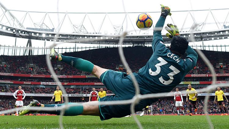 Peter Cech menepis tendangan penalti pemain Watford, Troy Deeney. - INDOSPORT