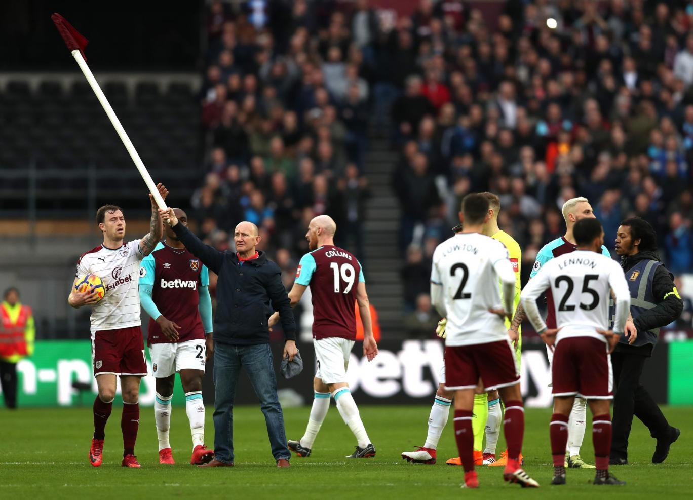 Seorang fans masuk lapangan dan mengangkat bendera corner. Copyright: EveningStandard