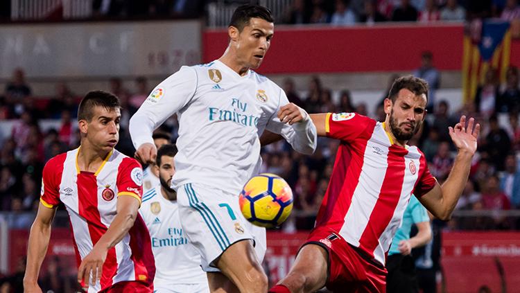 Cristiano Ronaldo berusaha mendahului pemain Girona untuk mendapatkan bola. Copyright: INDOSPORT
