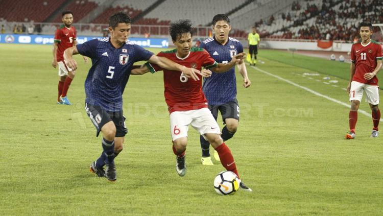 Muhammad Iqbal (tengah) dikawal ketat dua pemain Jepang. Copyright: Abdurrahman Ranala/INDOSPORT