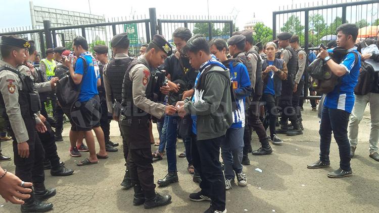 Petugas kepolisi memeriksa isi tas sejumlah Bobotoh.