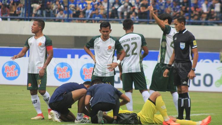 Syahrul Fadil mendapat pertolongan dari tim medis. Copyright: Arif Rahman/INDOSPORT