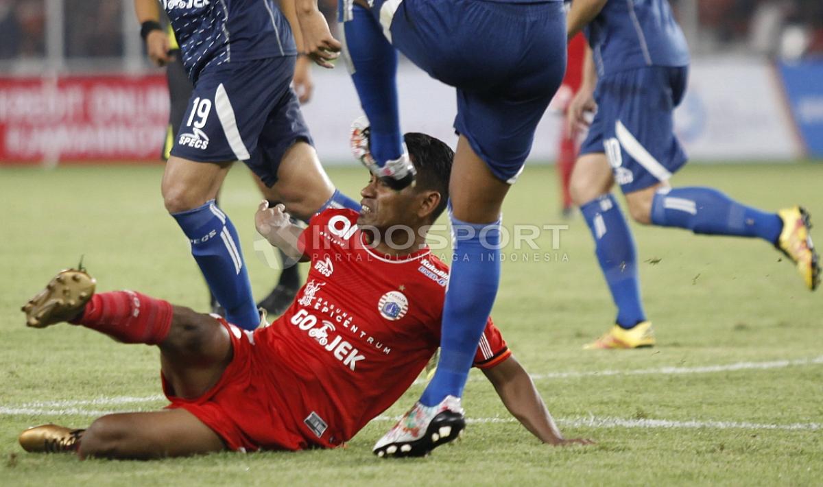 Perjuangan Ramdani Lestaluhu menghalau bola tendangan pemain Arema FC. Herry Ibrahim