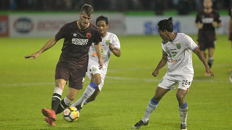 Wiljan Pluim (kiri) dalam bayang-bayang dua pemain Persela Lamongan.