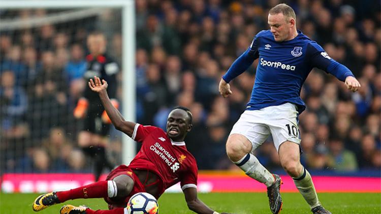 Sadio Mane (kiri) dan Wayne Rooney (kanan) sedang berebut bola dalam pertandingan laga premier Inggris Everton kontra Liverpool Copyright: INDOSPORT