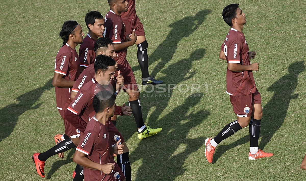 Para pemain Persija melakukan pemanasan sebelum melakukan latihan.