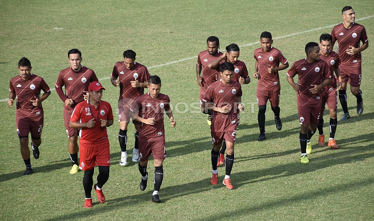 Para pemain Persija melakukan pemanasan sebelum melakukan latihan.