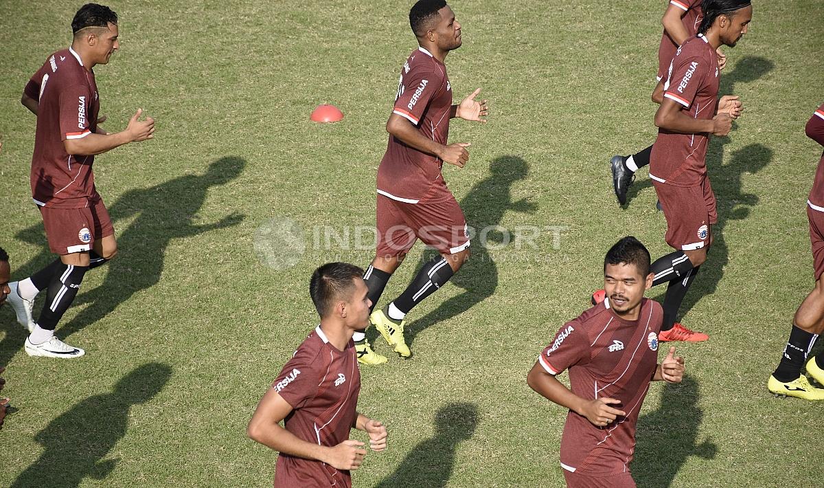 Para pemain Persija melakukan pemanasan sebelum melakukan latihan.