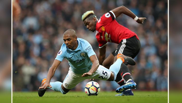 Fernandinho saat melawan gelandang serang Man United, Paul Pogba. Copyright: INDOSPORT