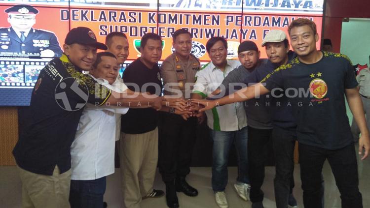Para pendukung Sriwijaya FC mengukuhkan aksi perdamaian. - INDOSPORT