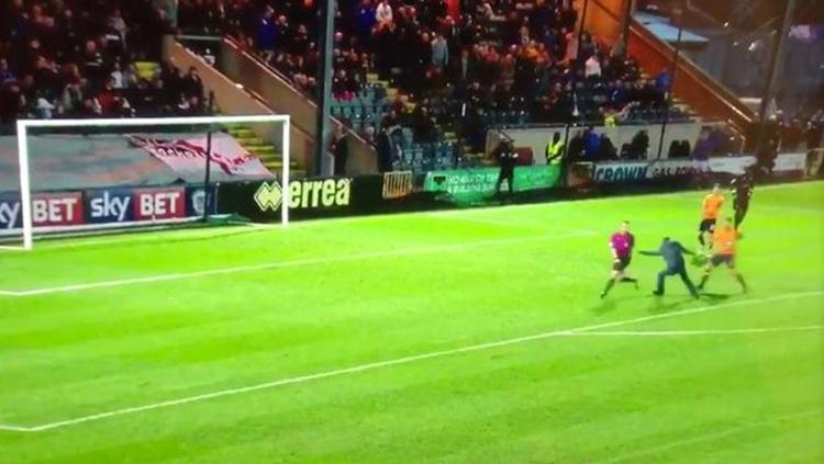 Pemain Oldham Athletic AFC menhentikan penyusup lapangan yang hendak menyerang wasit.
