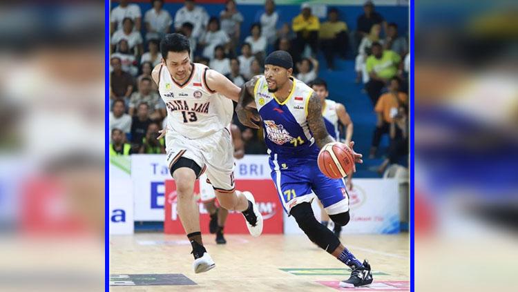 Jamarr Andre Johnson (kanan), power forward Satria Muda Pertamina Jakarta berduel dengan power forward Pelita Jaya Jakarta, Ponsianus 'Komink' Nyoman Indrawan. - INDOSPORT