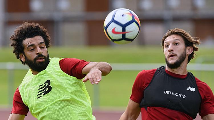 4 Bintang Gratisan yang Bisa Dibeli AC Milan di Bursa Transfer, salah satunya adalah Adam Lallana yang sedang berebut bola dengan Mohamed Salah.