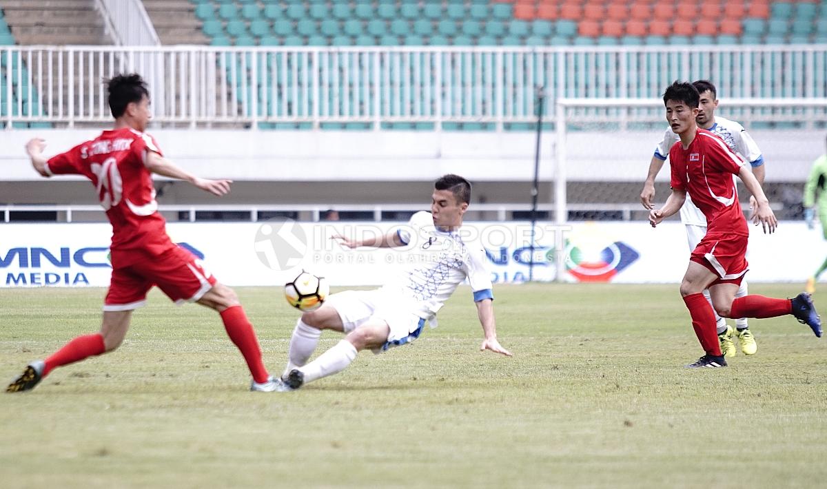 Duel antara pemain Uzbekistan dah Korut. Herry Ibrahim/INDOSPORT.