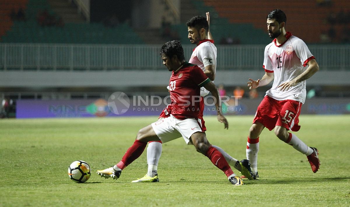 Ilham Udin tampak dijaga dan mencoba tetap menguasai bola.