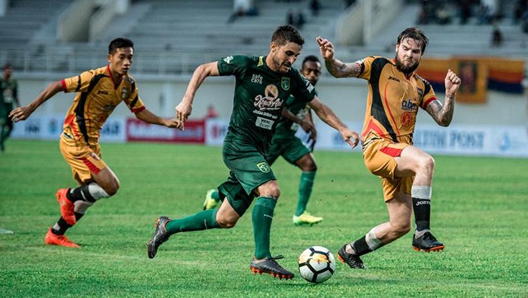 Robertino Pugliara melewati dua pemain Mitra Kukar.