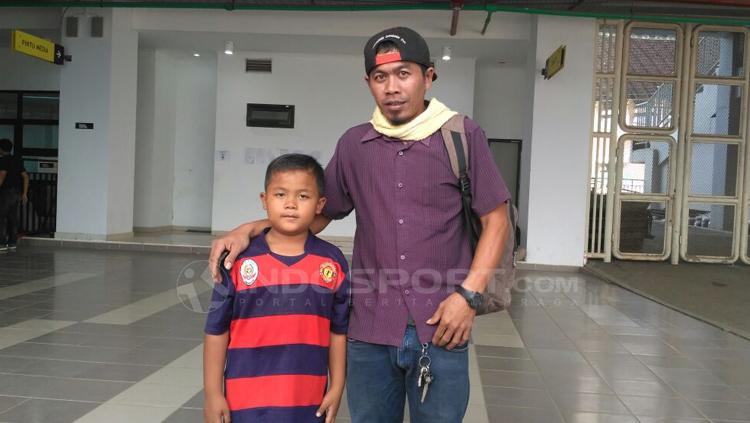 Alfarizi bocah kecil (kiri) menyaksikan laga Indonesia U-23 vs Korea Utara U-23 di Pakansari.