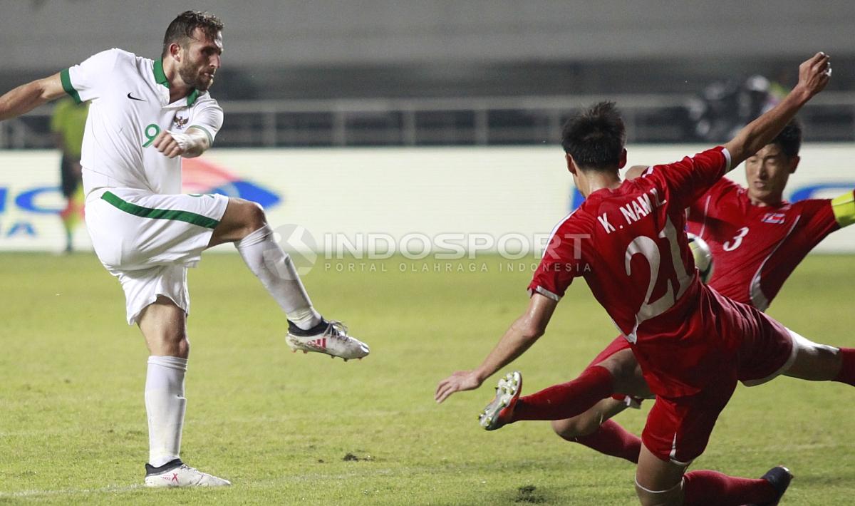 Tendangan keras Spaso berhasil digagalkan dua pemain Korea Utara.