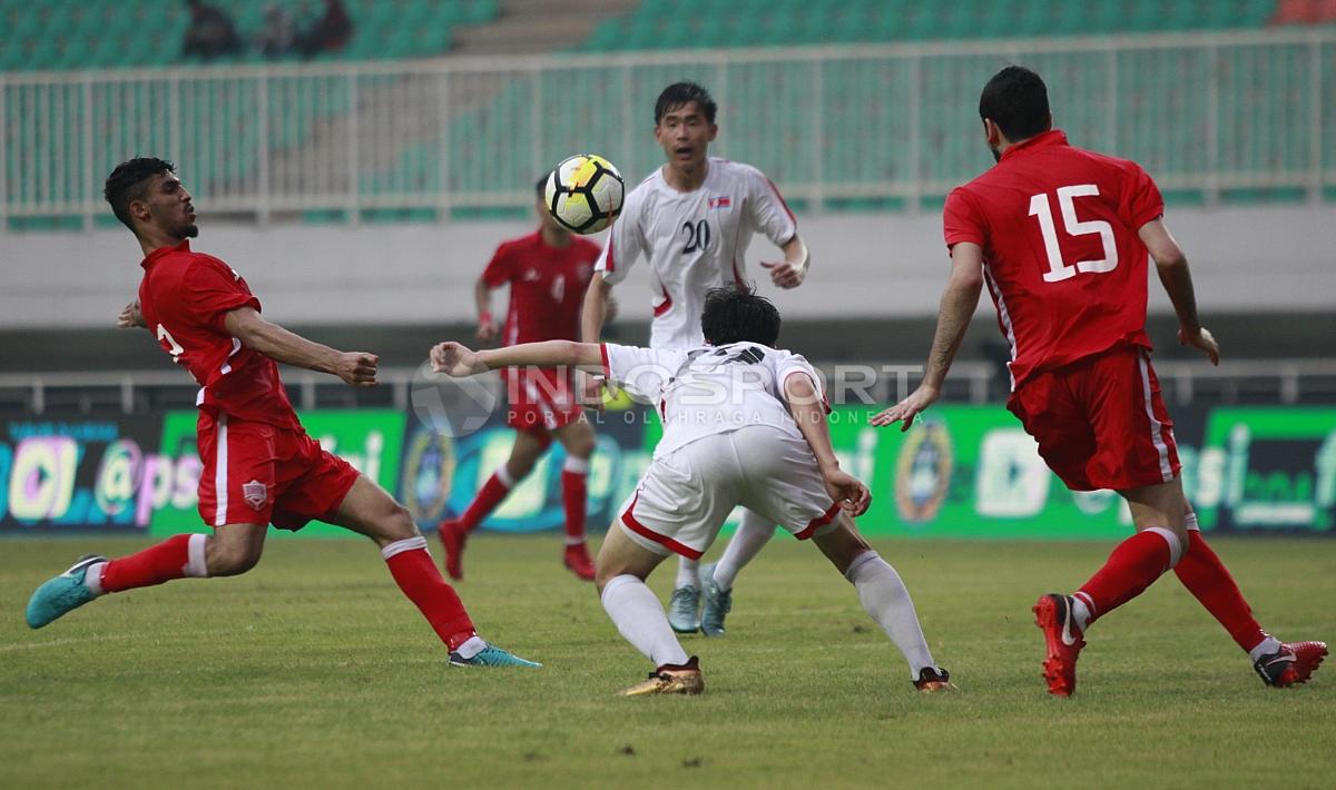 Perebutan bola antara pemain Korea Utara dengan pemain Bahrain. Herry Ibrahim