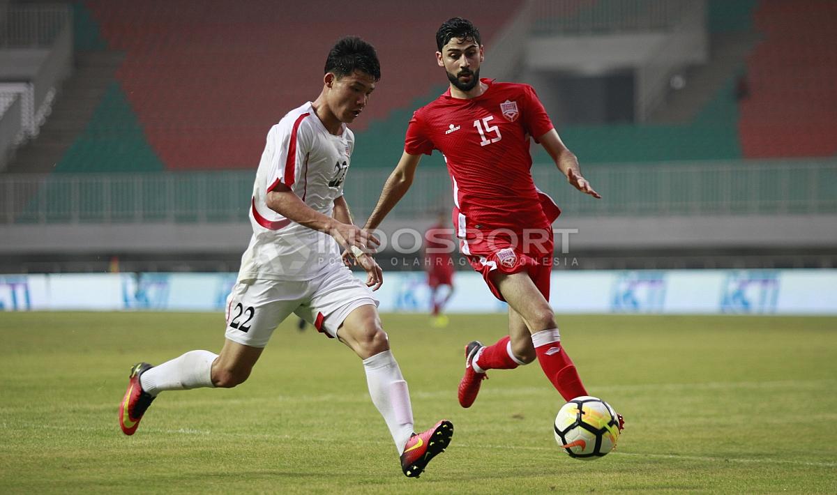 Aksi pemain Korea Utara, Kang Kuk Chol (kiri) dijaga ketat pemain Bahrain, Hasan Alkarrani. Herry Ibrahim