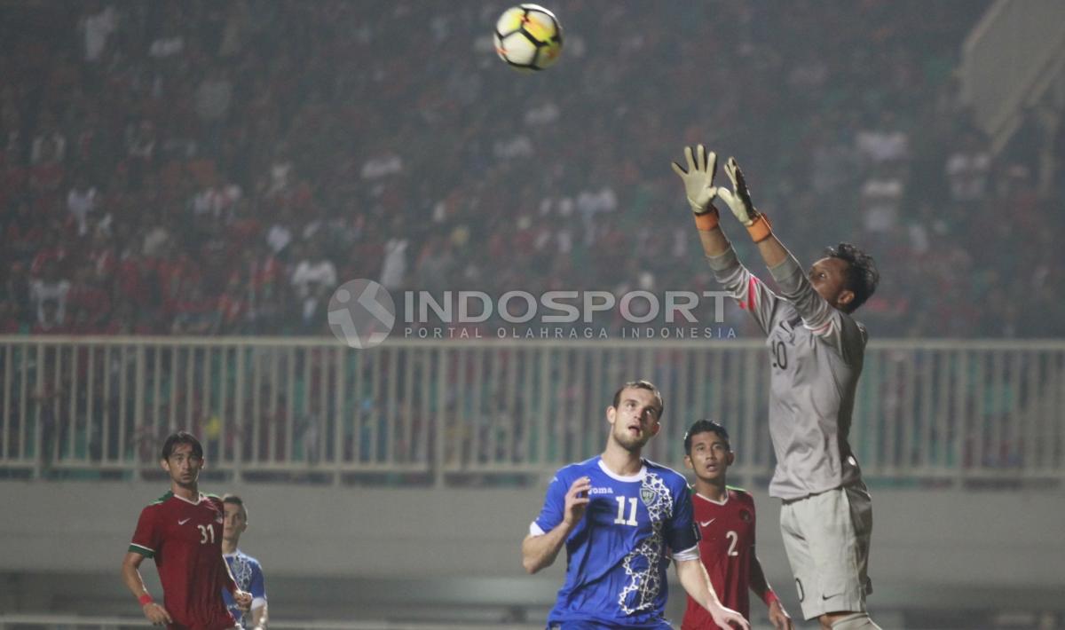 Kiper Indonesia, Awan Setho mengamankan bola dari serangan Uzbekistan. Herry Ibrahim