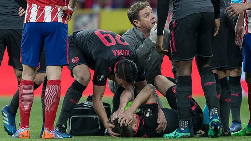 Indosport - Laurent Koscielny mengerang kesakitan.