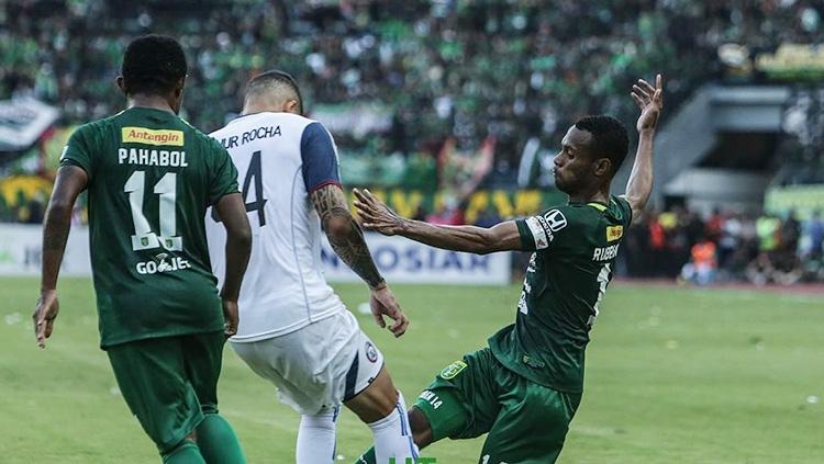 Arthur Cunha dikawal ketat dua pemain Persebaya Surabaya.