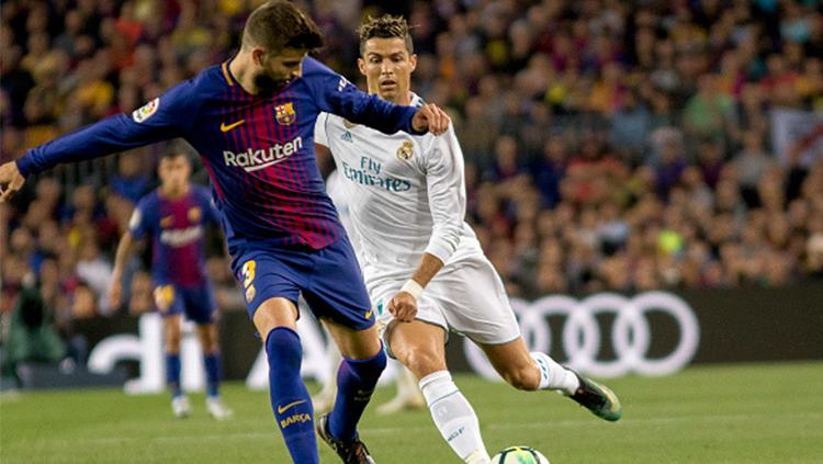 Gerard Pique (kiri) menjaga penguasaan bola dari kejaran Ronaldo.
