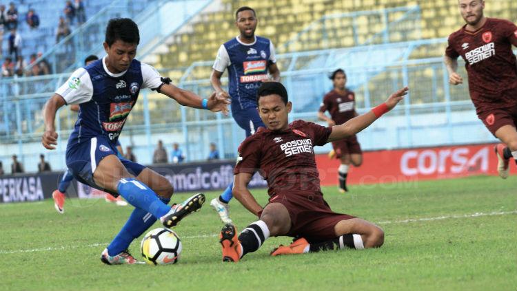 Dedik Setiawan berusaha menjaga bola dari penggawa PSM