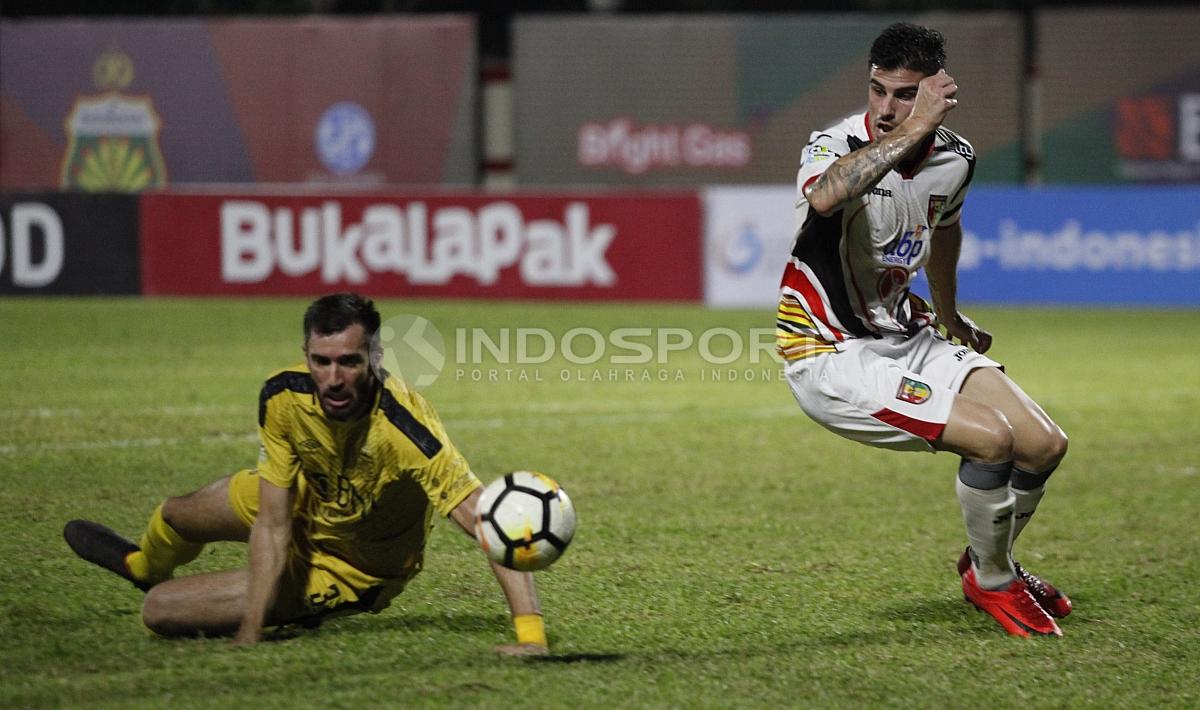 Vladimir Vujovic saat kehilangan bola dalam duel dengan Fernando Rodriguez.