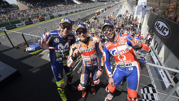 Marc Marquez bersama Danilo Petrucci dan Valentino Rossi berdiri di podium. - INDOSPORT