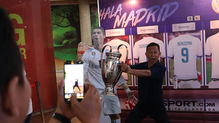 Madridista berfoto bersama replika Trofi Liga Champions.