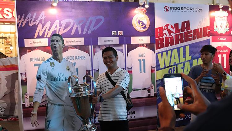 Madridista berfoto bersama replika Trofi Liga Champions.