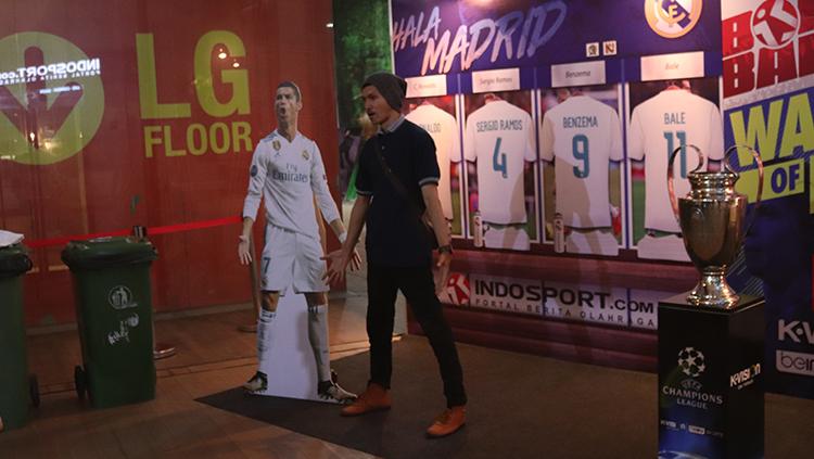 Fans Real Madrid berfoto di depan backdroop El Real.