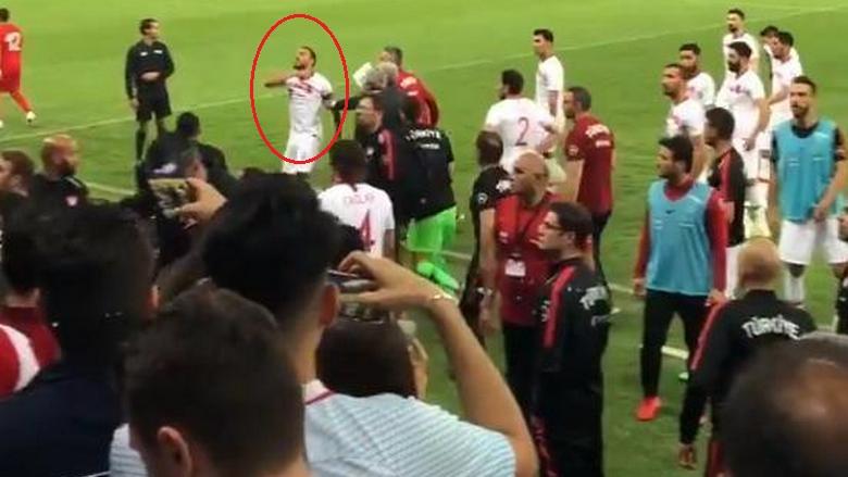 Penyerang Turki, Cenk Tosun melakukan gestur memotong leher ke fans, Sabtu (02/06/18).