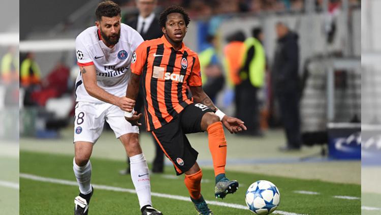 Fred sedang melindungi bola dari pemain PSG.