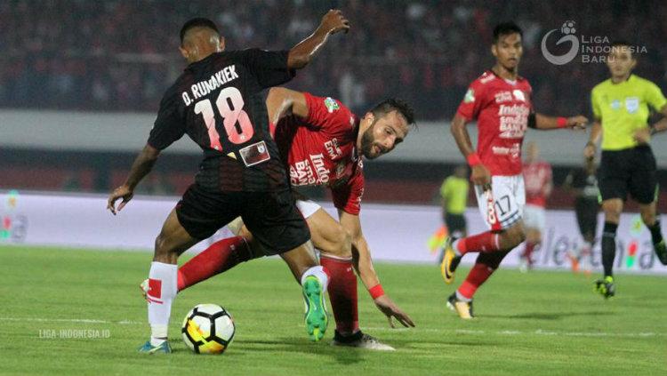Ilija Spasojevic yang berusaha merebut bola David Wato Rumakek.